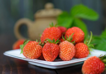 Ripe strawberry on a white plate.