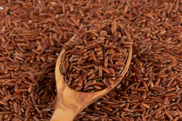 Red rice in a wooden spoon