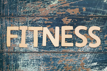 Word fitness written with wooden letters on rustic surface
