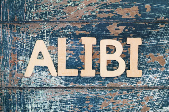 Word alibi written with wooden letters on rustic surface
