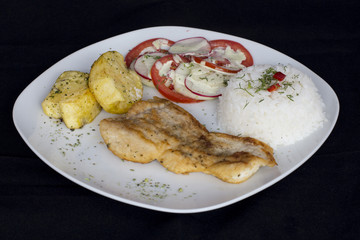 Grilled fish and vegetables, potatoes, rice, tomatoes and chicha morada.