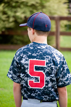Baseball boy outside from behind in camo jersey
