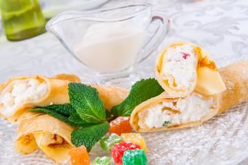 Rolled crepes with cottage cheese and candied fruits