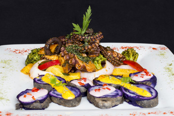 Grilled Octopus, gourmet dish from Peru. Served with purple potatoes.