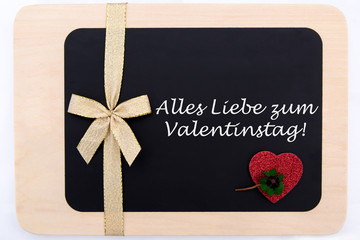 rotes Herz und ein Kleeblatt auf einer Tafel