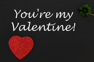 ein rotes Herz und ein Kleeblatt auf einer Tafel