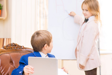 Boy holding tablet and girl at the whiteboard.