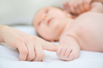 Infant holding finger of the mother 