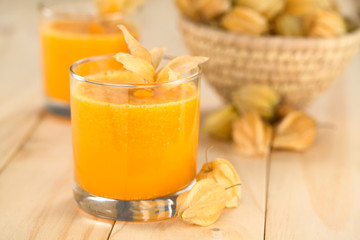 Freshly prepared juice made of physalis (lat. Physalis peruviana) served in glass (Selective Focus, Focus on the front of the glass rim)