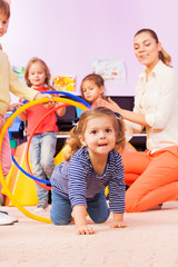 Girl go though hoops playing game in kindergarten