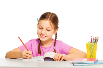 Pretty diligent girl in pink tee learns at school