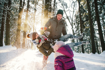 Beautiful family laughing in winter forest