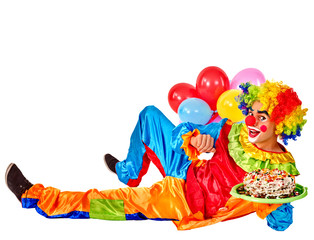Obraz na płótnie Canvas Happy birthday clown holding cakes and bunch of balloons lying on floor. Isolated.