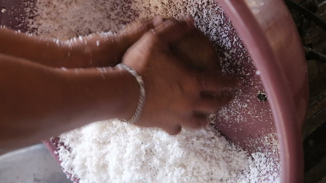 Woman on a public market extraction of coconut shavings.Asian market