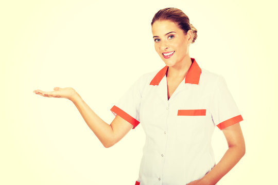 Smiling female doctor or nurse pointing at something