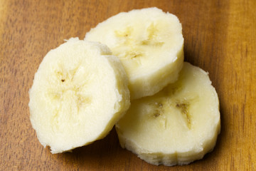 Sliced bananas on wooden background