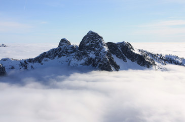 The Lions above the clouds in North Shore Mountains, BC, Canada. 