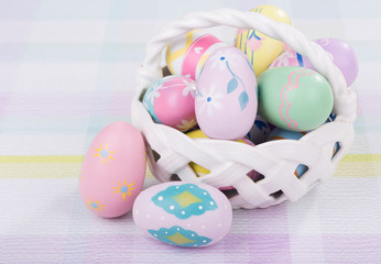 Fototapeta na wymiar Painted Easter Eggs and Basket on Colorful Table