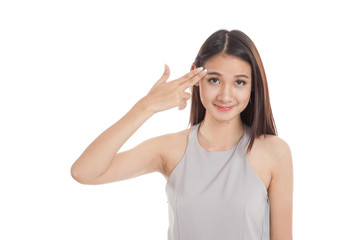 Beautiful young Asian woman holding fingers in gun gesture