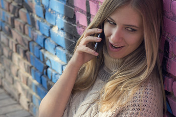 Fototapeta premium Young blonde woman talking over phone and smiling