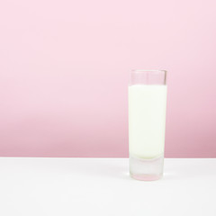The tasty homemade panna cotta (Italian pudding dessert) in the small glass on white table.