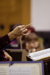 The hands of the conductor on the background of the orchestra