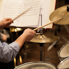 Hands of a man playing a drum set in motion