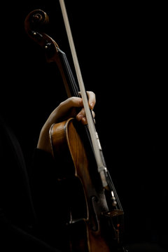 Hand girl holding a violin on a black background