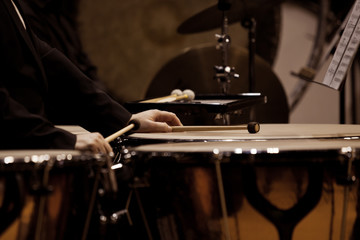 Hands musician playing timpani in dark colors closeup