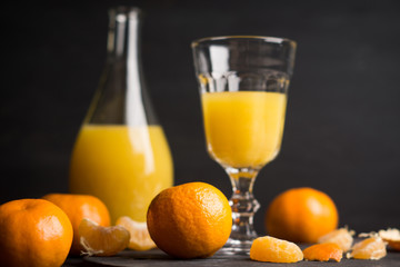 Oranges and juice on the dark background. Shallow depth of field. 