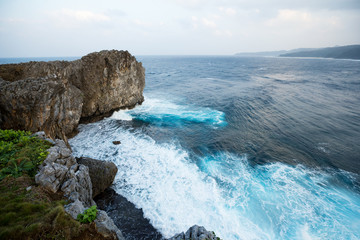 Waves crashing over rock formation cliff