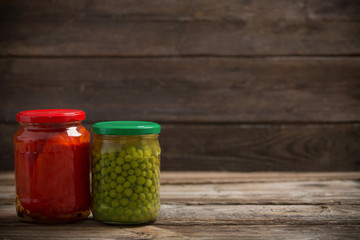 Jars with pickled vegetables on wooden background