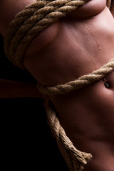 Fototapeta na wymiar gefesselte devote und nackte Frau, stehend mit einem Seil