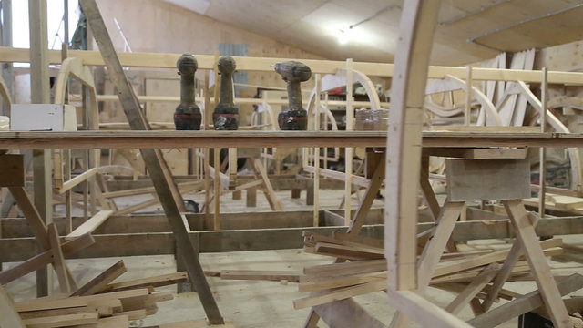 Start of construction of a boat at the shipyard, frames installed on the slipway, screwing on the bench in the carpentry workshop
