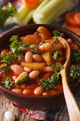Bean soup with tomatoes and celery close-up. vertical
