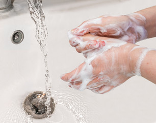 Washing hands with soap and water.