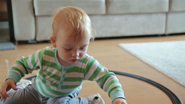 Little boy with mother playing with toy train