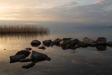 reeds, rocks and their reflections at sunset on Lake Iznik, Turkey