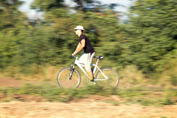 Fototapeta na wymiar cyclist with a backpack walking along the footpath