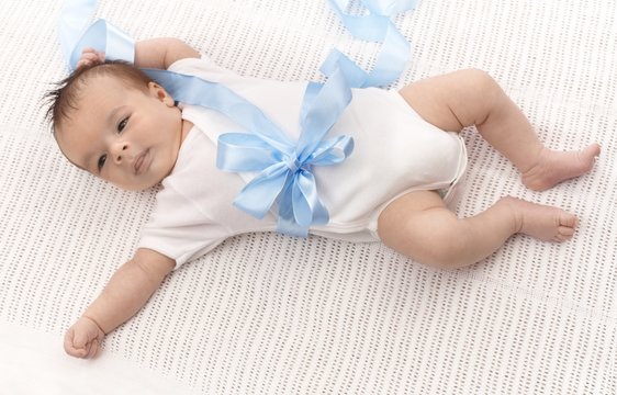 Baby boy in bodysuit and blue ribbon