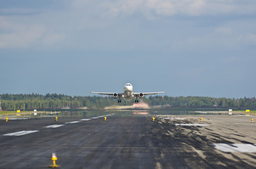Fototapeta premium Front view on runway with taking off jet airplane