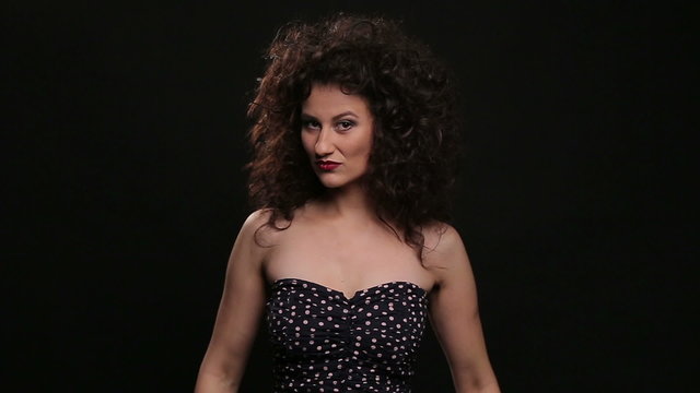 Young brunette with long brown curly hair dancing 