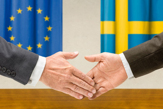 Vertreter der EU und Schwedens reichen sich die Hand