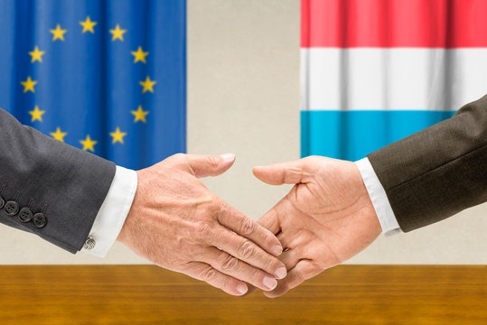 Vertreter der EU und Luxemburgs reichen sich die Hand