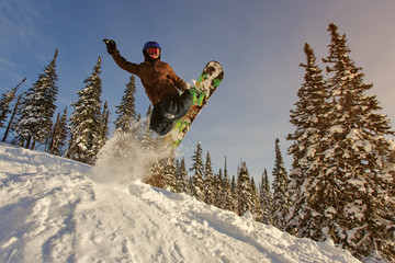 Snowboarder jumping through air with deep blue sky in background