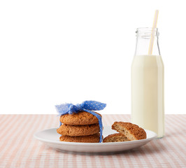 Oatmeal cookies, halves of cookies on plate, bottle of milk