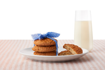 Oatmeal cookies, halves of cookies on plate, glass of milk