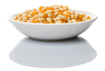 Raw popcorn in white bowl over wooden background