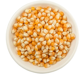 Raw popcorn in white bowl over wooden background