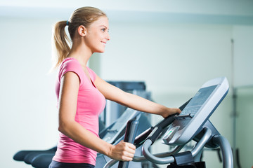 Fototapeta na wymiar Woman exercising on treadmill in gym